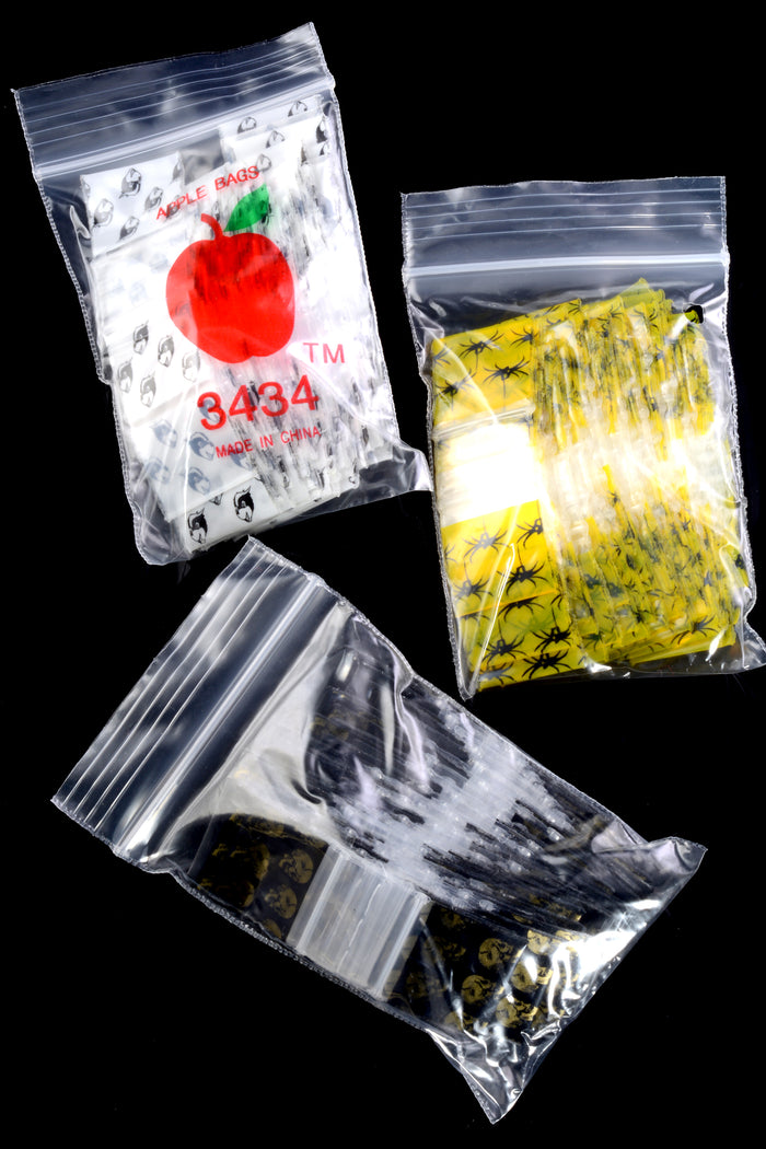 Selection of Apple Bags ¾-inch mini zip baggie bundles—blue, yellow, spider, skull, and mask prints—shown in clear outer pouches on black background