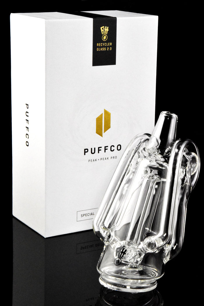 Angled shot of Ryan Fitt Recycler Glass 2.0 with Special Edition Puffco packaging on a black background for a premium look.